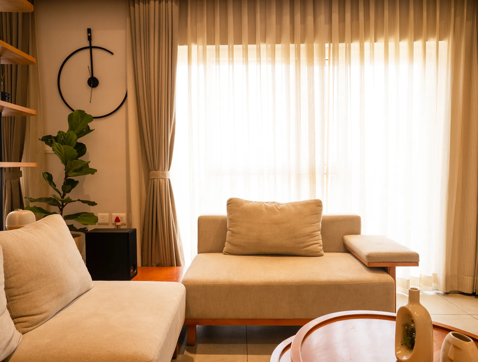 Living room with cream lounger and floor-to-ceiling curtains — Amlan's Residence